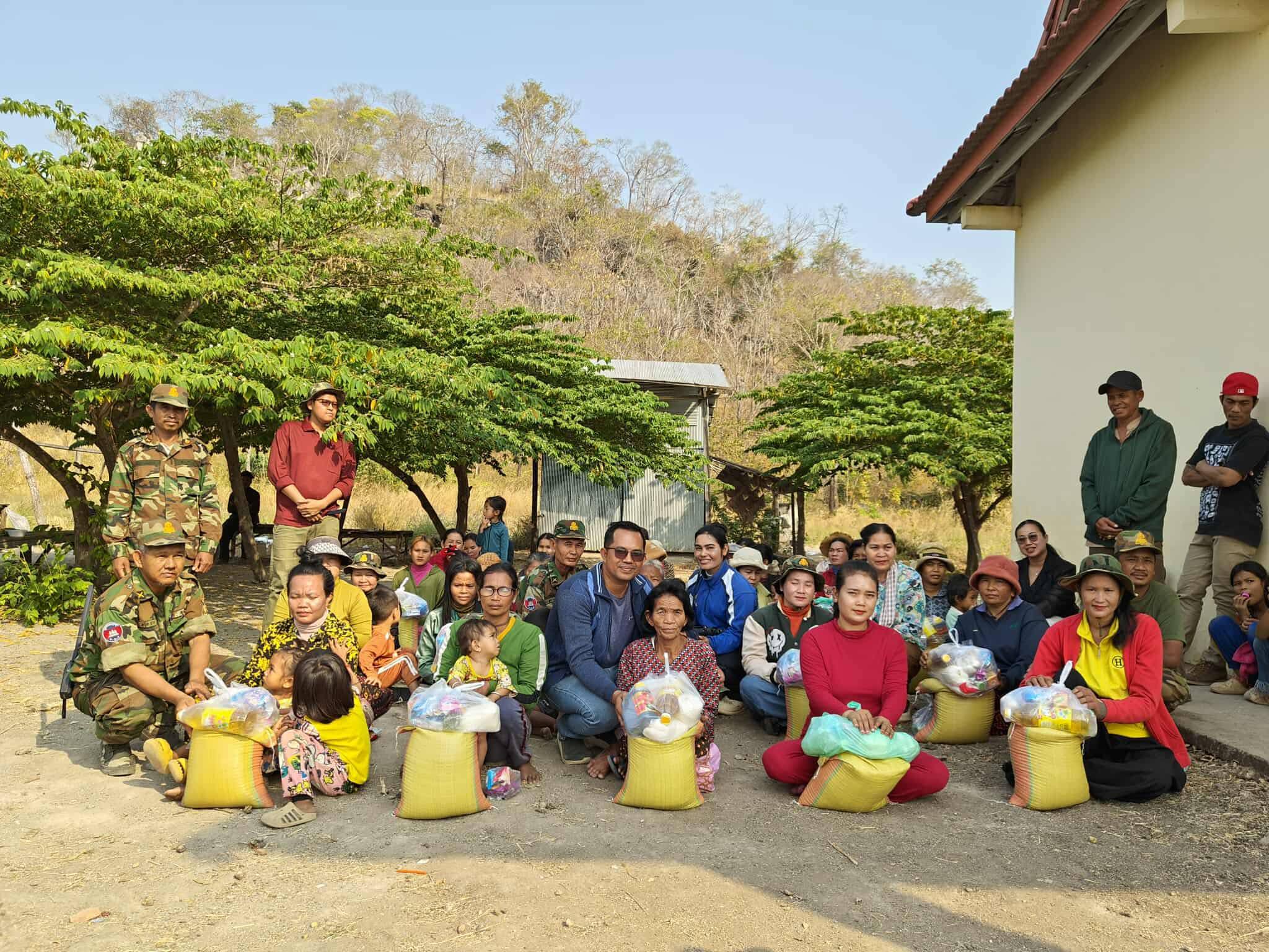 Cambodian families with children holding bags of emergency food relief, February 2026